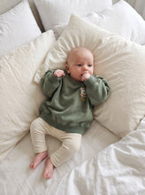 Load image into Gallery viewer, Baby wearing sage Bear-y Warm organic cotton sweatshirt with cream leggings