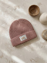 Load image into Gallery viewer, Dusty pink cotton knit beanie hat for babies and children with folded ribbed cuff, photographed flat on a neutral textured background.