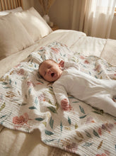 Load image into Gallery viewer, Newborn baby resting on a floral 4-layer muslin blanket with soft flower print and breathable cotton texture
