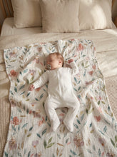 Load image into Gallery viewer, Sleeping newborn baby lying on a floral organic cotton muslin blanket in a cosy nursery bed