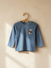 Load image into Gallery viewer, Dusty blue baby and kids long sleeve t-shirt with embroidered French bulldog detail hanging on wooden hanger