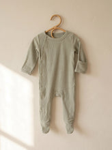 Load image into Gallery viewer, Organic ribbed footed baby sleepsuit in sage green made from 95% organic cotton hanging on a wooden hanger.