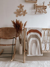 Load image into Gallery viewer, rainbow knit baby blanket draped over a crib – warm earthy tones