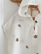 Load image into Gallery viewer, hooded floral muslin poncho shown on wall hook – organic baby outerwear