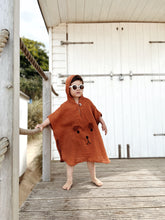 Load image into Gallery viewer, toddler boy posing in burnt orange baby poncho – breathable cotton outerwear