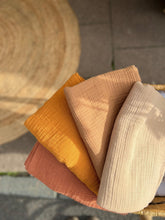 Load image into Gallery viewer, flat lay of four muslin baby blankets labeled cinnamon, beige, mustard