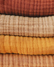 Load image into Gallery viewer, stack of organic muslin baby blankets in earthy tones – cinnamon, mustard, beige, and camel
