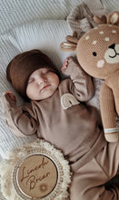 Load image into Gallery viewer, newborn resting peacefully in two-piece beige baby set with rainbow motif
