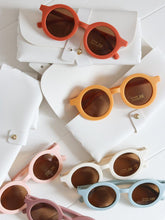 Load image into Gallery viewer, close-up of baby sunglasses scattered on white wooden surface – natural light product shot