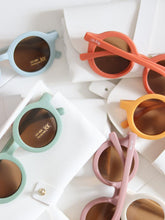 Load image into Gallery viewer, 	angled close-up of baby sunglasses in various colours – soft organic display