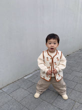 Load image into Gallery viewer, Toddler wearing cream quilted dachshund gilet layered over a sweatshirt with neutral trousers
