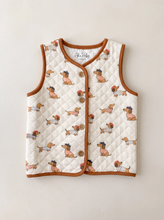 Load image into Gallery viewer, Cream quilted organic cotton baby and toddler gilet with dachshund print and rust trim
