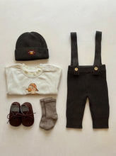 Load image into Gallery viewer, Khaki Knit Braces Trousers styled with a duck print baby T-shirt, matching knit beanie, leather baby shoes and ribbed socks on a neutral background.
