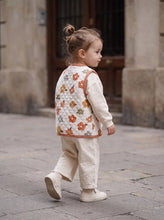 Load image into Gallery viewer, Toddler wearing cream retro floral quilted gilet with terracotta trim over a neutral outfit
