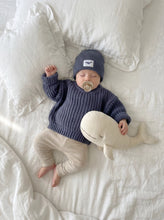 Load image into Gallery viewer, Baby sleeping in a white linen bed wearing Ada Baby dusty blue oversized chunky knit jumper, matching beanie and knit leggings with a soft whale plush.
