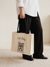 Load image into Gallery viewer, Ada Baby natural reusable shopping tote bag featuring Bury St Edmunds design, carried by a model.
