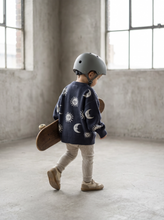 Load image into Gallery viewer, Toddler wearing the oversized Celestial Knit Jumper featuring a knitted sun and moon design, shown from the back.
