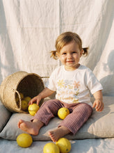 Load image into Gallery viewer, Toddler wearing organic cotton Isn’t She Lovely floral graphic t-shirt while sitting with lemons and wicker basket
