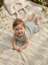 Load image into Gallery viewer, Baby wearing sage palm print muslin romper smiling on striped blanket

