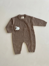 Load image into Gallery viewer, Cotton sheep knit baby onesie in warm taupe with an asymmetric button fastening and textured sheep pocket.
