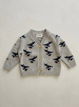 Load image into Gallery viewer, Grey 100% cotton baby and toddler knit cardigan featuring an all-over whale intarsia design with wooden buttons, displayed flat on a warm neutral background.
